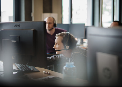 Mann mit Headset am Monitor